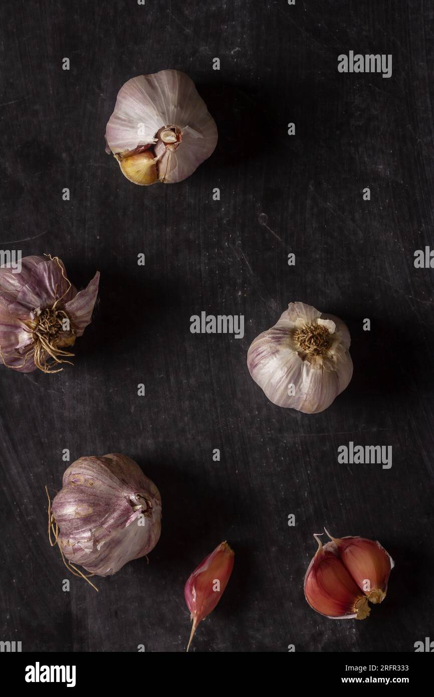 Fresh garlic bulbs and cloves grouped on black background. Flat lay ...