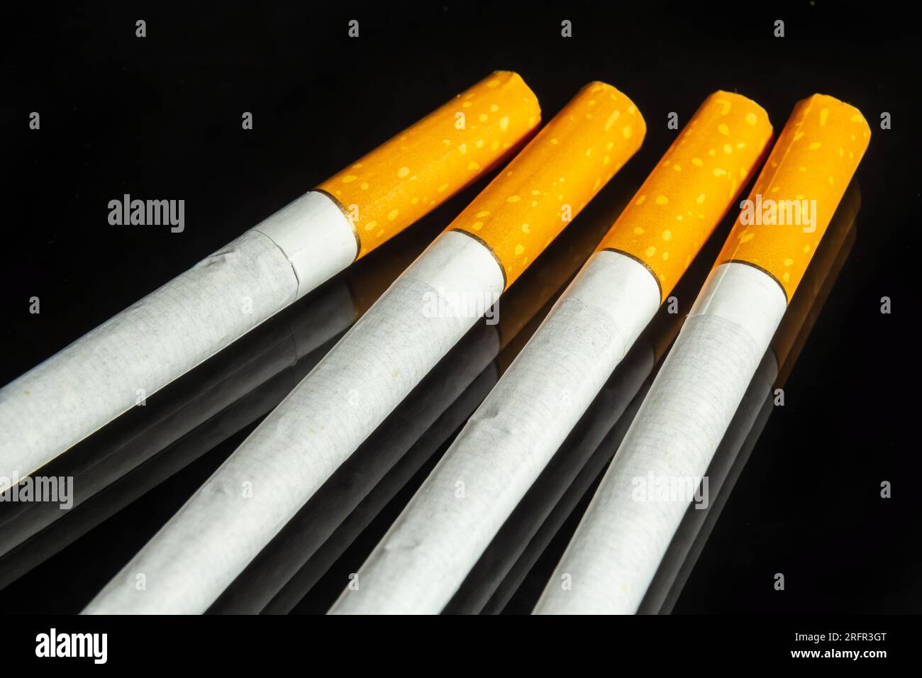 some white and brown cigarettes, cigarettes allowed only for over eighteen, black background. Stock Photo