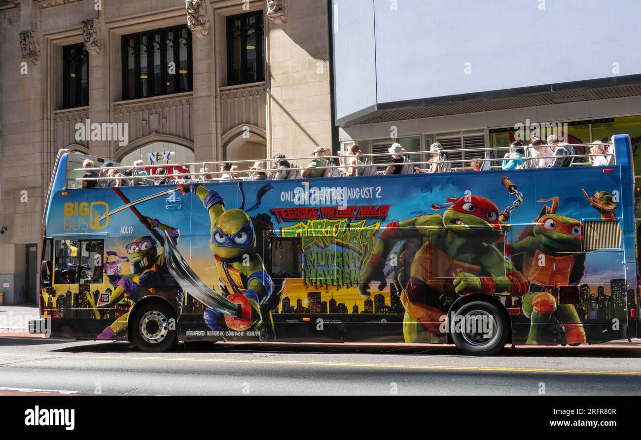A Double Decker sightseeing bus features a 'Teenage Mutant Ninja Turtle' movie ad near Times Square, 2023, New York City, USA Stock Photo