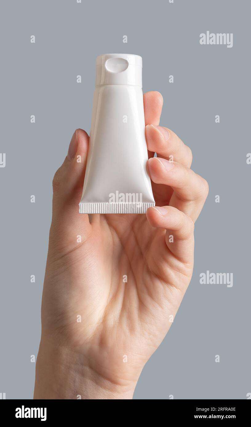 Hand holding cream tube mockup, blank package mock up Stock Photo - Alamy