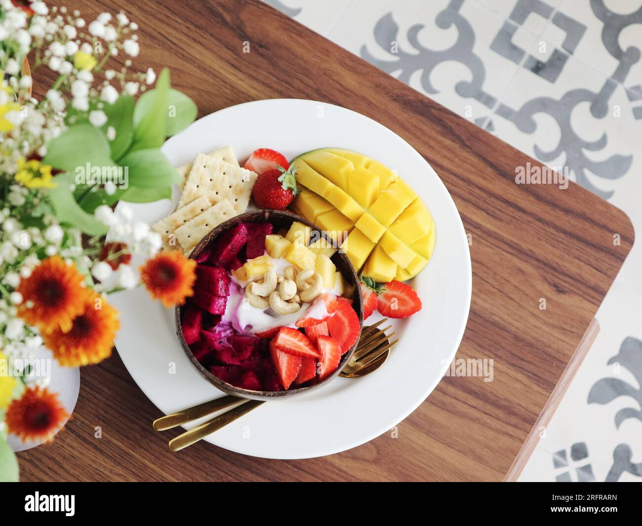 https://c8.alamy.com/comp/2RFRARN/smoothie-bowl-with-mango-strawberry-dragon-fruit-and-cashew-in-coconut-bowl-closeup-2RFRARN.jpg