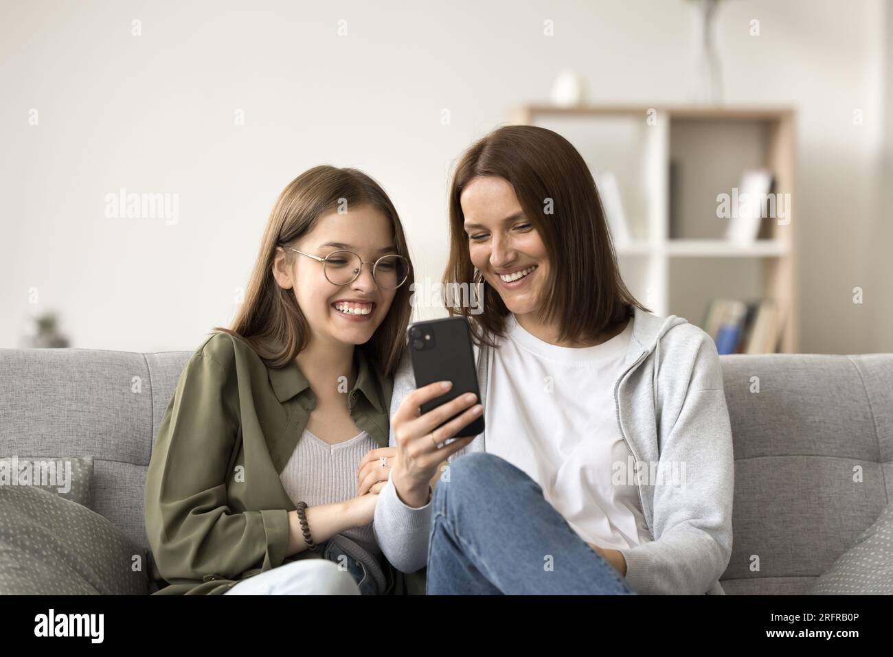 Happy mom and pretty teenage kid using app on phone Stock Photo - Alamy