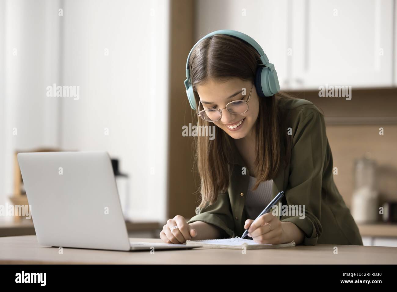 Happy teen student girl in glasses studying at laptop Stock Photo - Alamy