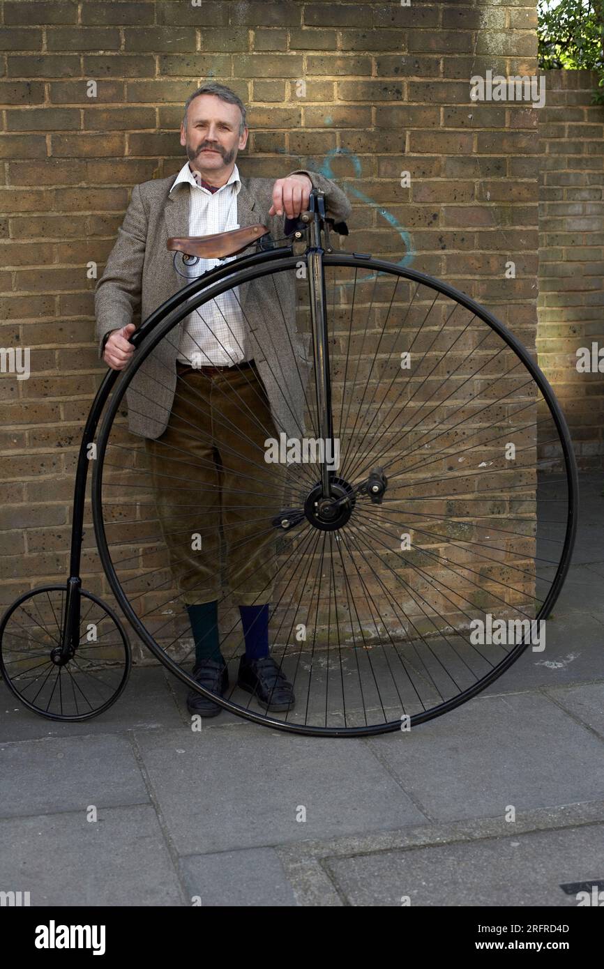 Man passing with Penny Farthing bicycle. Stock Photo