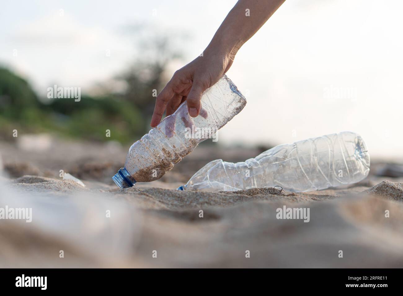 Volunteer picking plastic bottle clean up day, collecting waste on sea