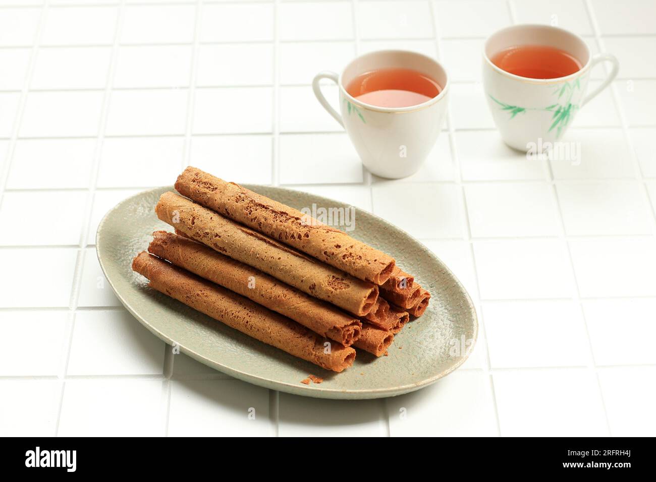 Kue Semprong Chinese Waffle Egg Roll, Served with Tea Stock Photo