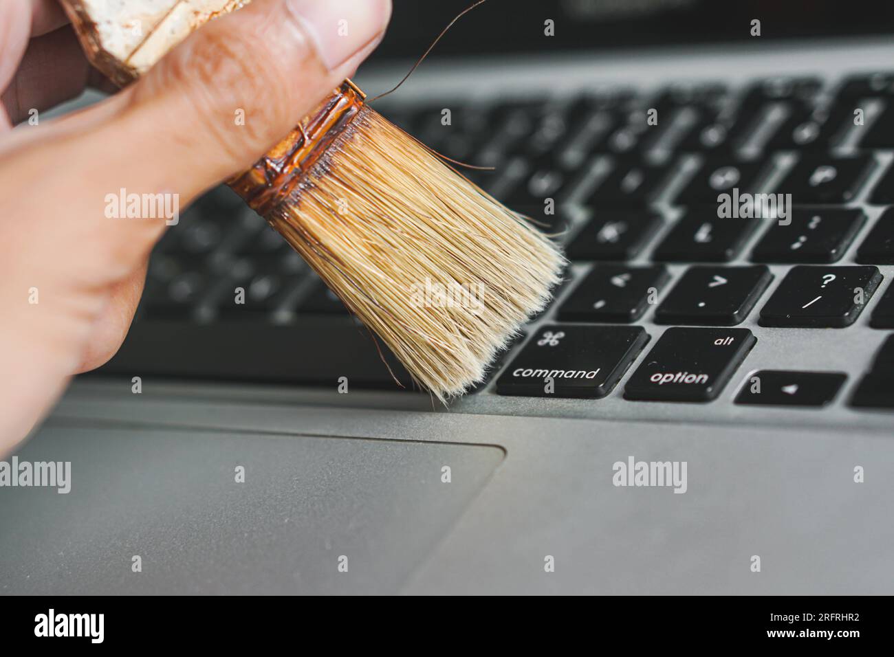 cleaning dust from computer keyboard Stock Photo - Alamy