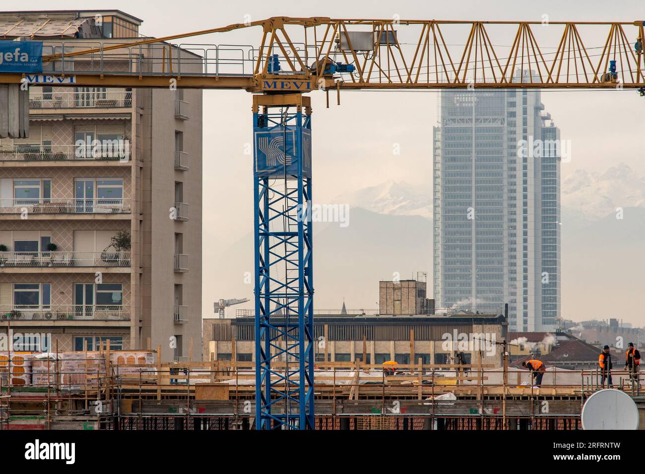 Rooftop view of a construction site with workers in the city centre and