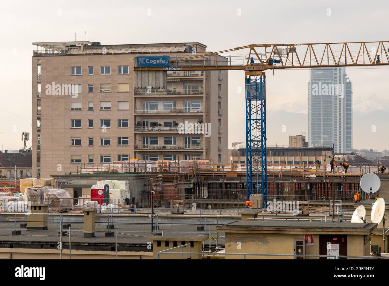 Rooftop view of a construction site with workers in the city centre and