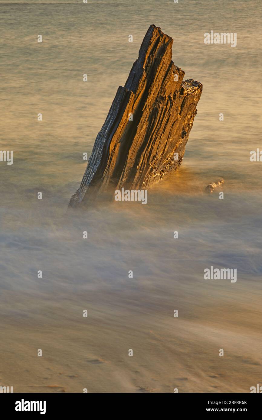Shoreline rock washed by waves on a rising tide at sunset; Ayrmer Cove ...