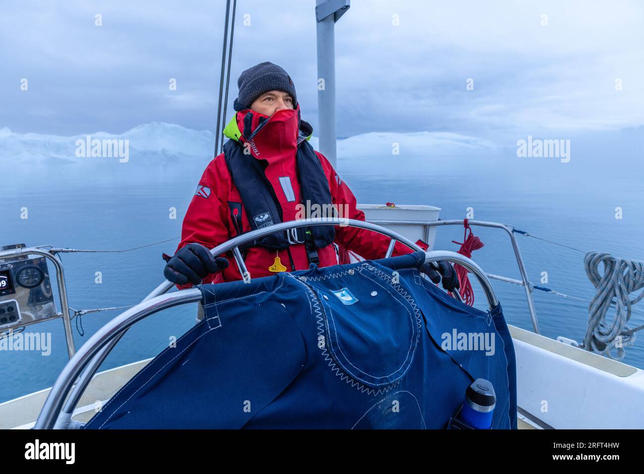 Captain sailing above the Arctic Circle in Disko Bay, Greenland Stock Photo