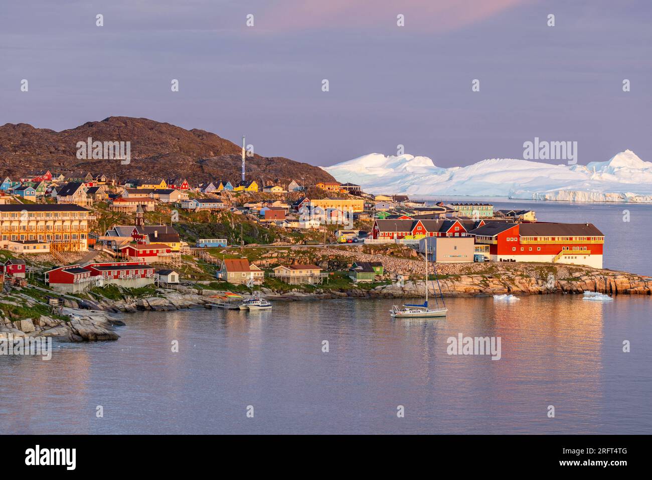 Ilulissat village at sunrise set against Kangerlua icefjord, Greenland Stock Photo