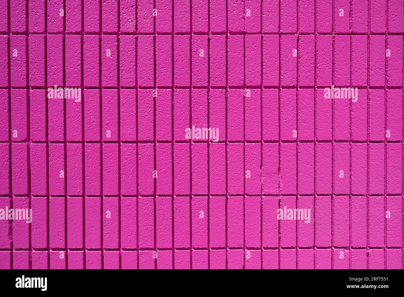 Background from a wall made of rectangular pink mosaic tiles Stock Photo