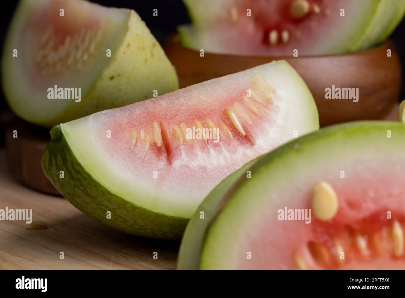 cut small unripe watermelon on a board, cut into pieces unripe