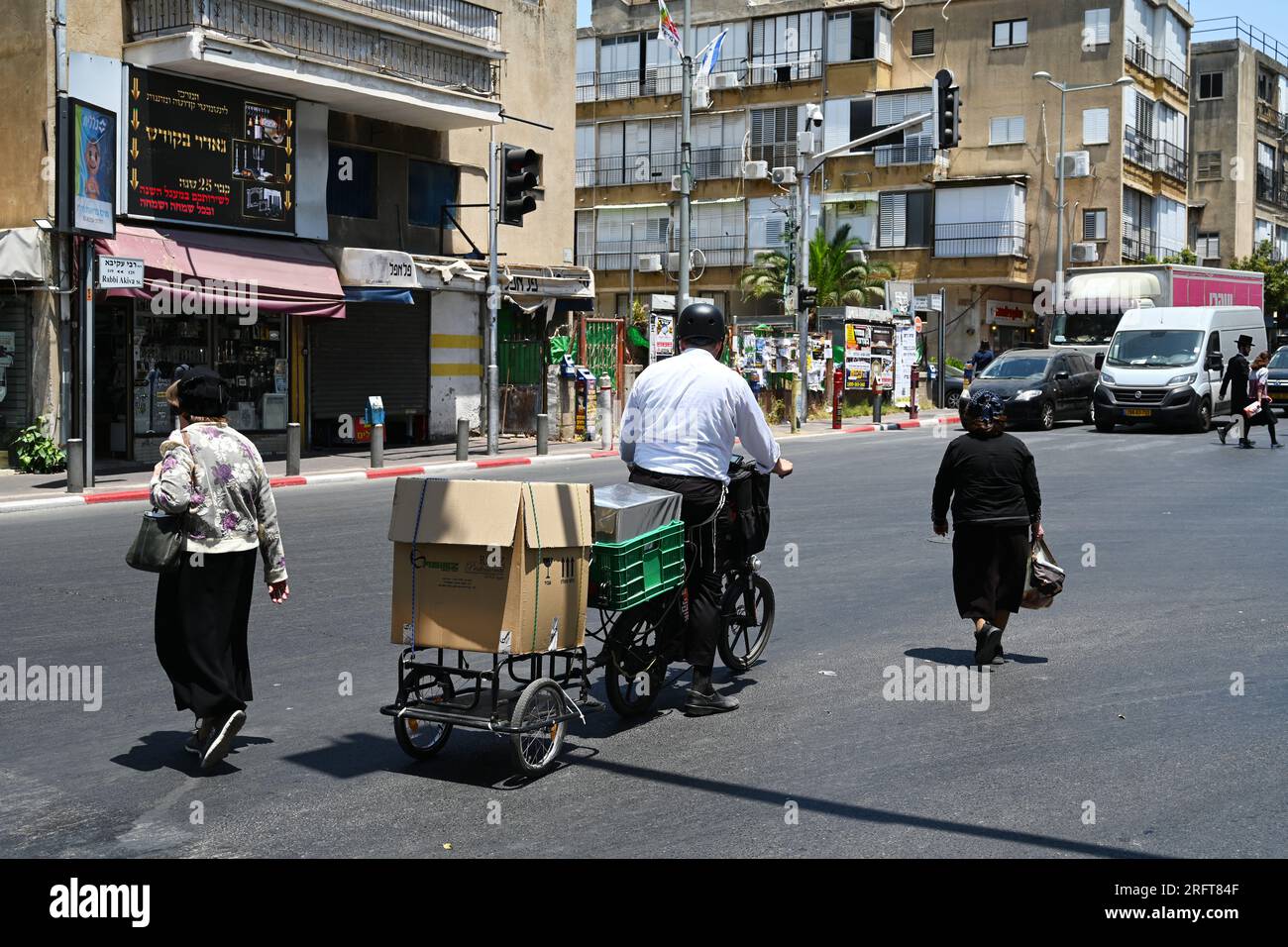 Chasidic man on bicycle with trailer Stock Photo