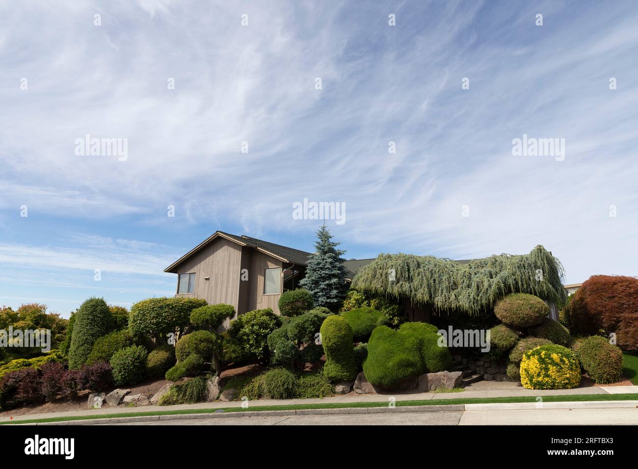 Lush landscaping envelopes a home in Seattle’s affluent North Admiral neighborhood Stock Photo