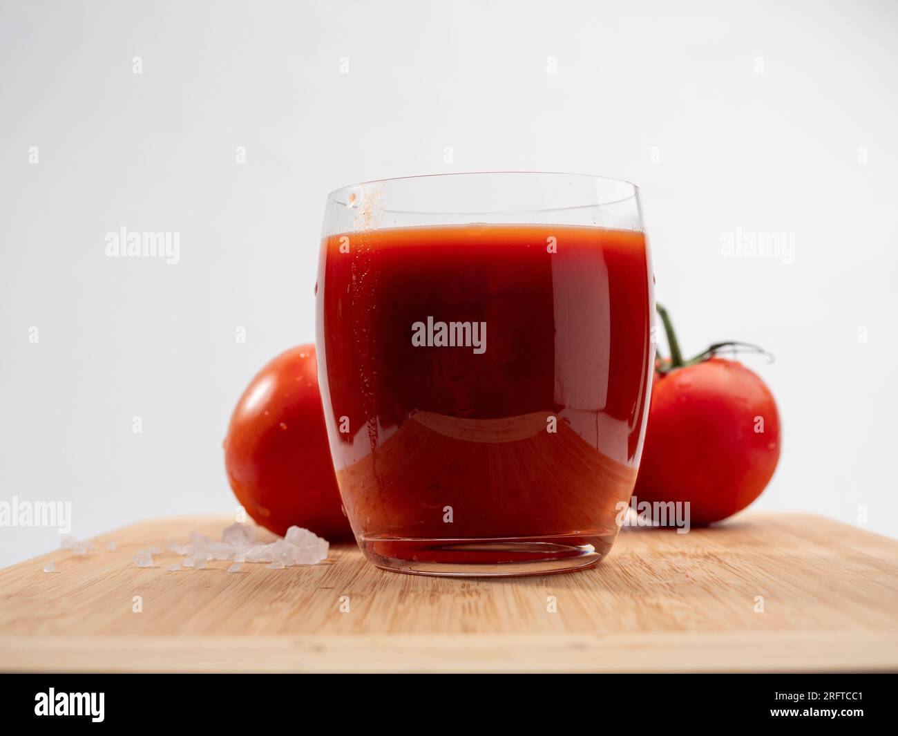 Glass of tomato juice and tomatoes on a white background. Freshly