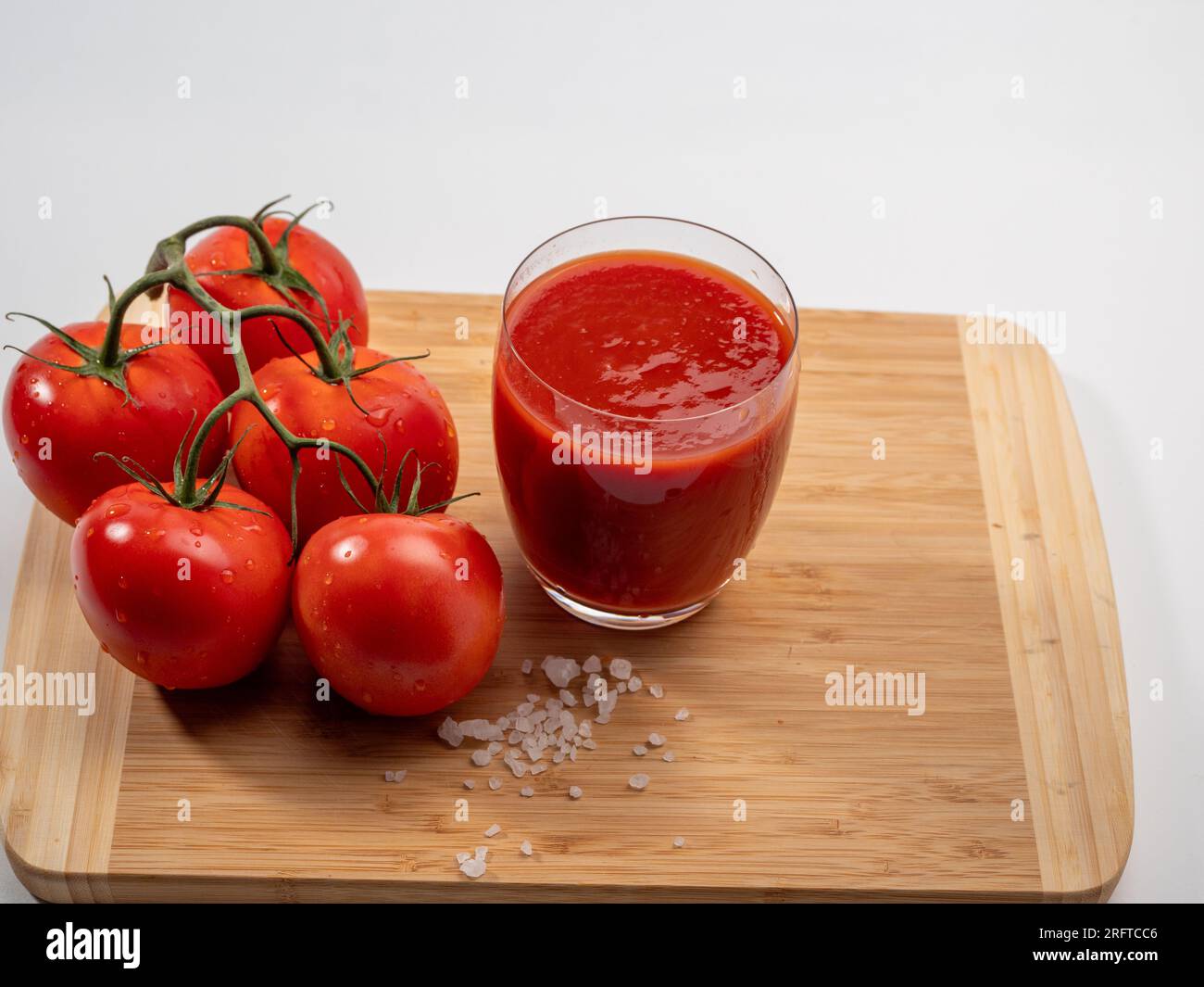 Glass of tomato juice and tomatoes on a white background. Freshly