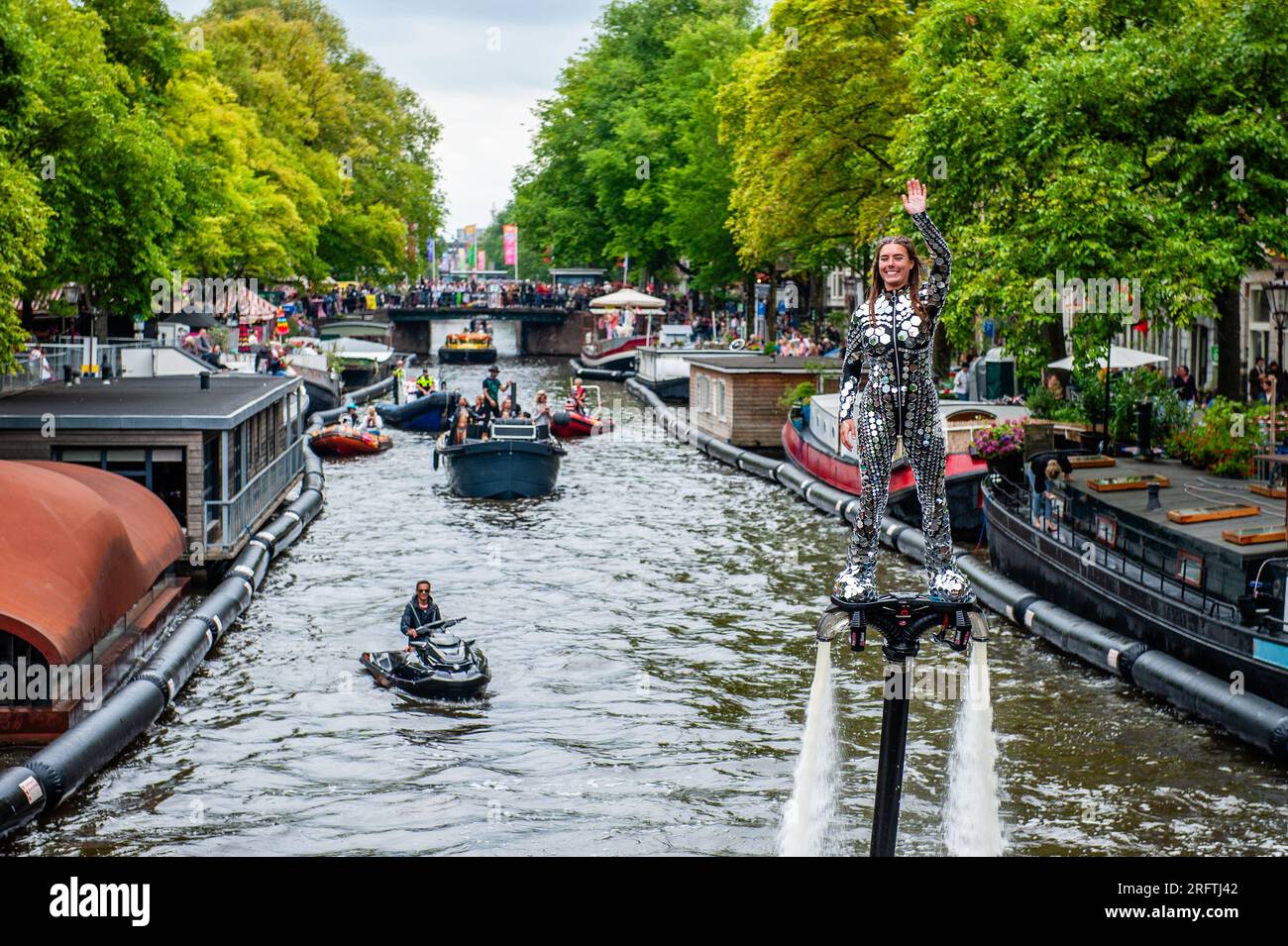 A woman is seen using a hydroflighting device to fly on the water during the event. The Canal Parade starts around noon and takes all afternoon. Around 80 boats of different organisations and non-profit organisations participate in the event. The Canal Parade is what Amsterdam Gay Pride is famous for. It's the crown of their two weeks lasting festival that features more than 200 events. The boats start at the Scheepvaart museum in the eastern part of the city center moving towards the Amstel River. (Photo by Ana Fernandez/SOPA Images/Sipa USA) Stock Photo