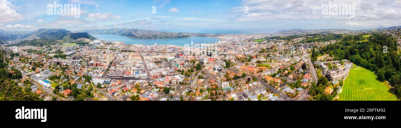 Coastal port city Dunedin on the South island of New Zealand - scenic wide aerial panorama over downtown. Stock Photo