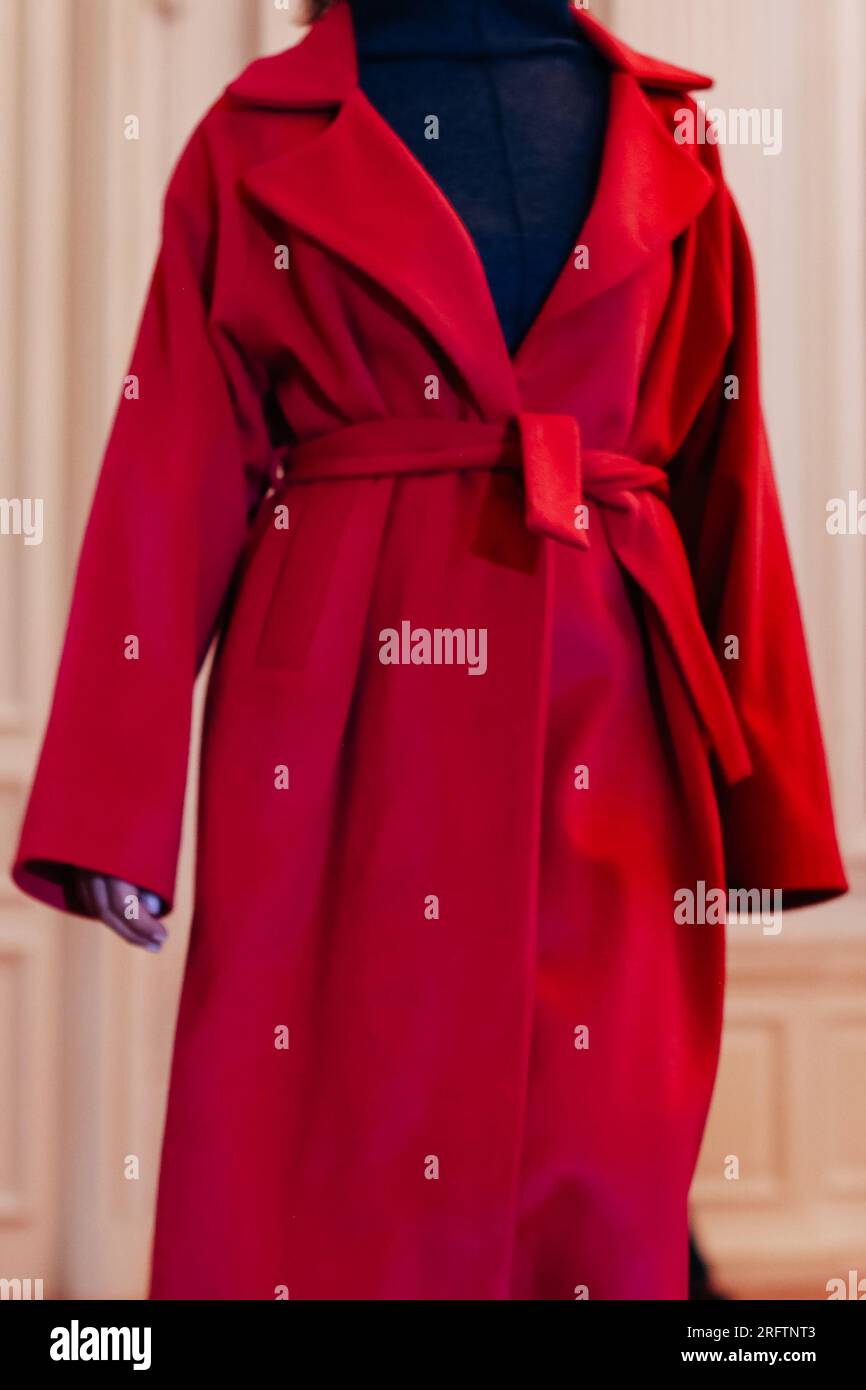 Cropped figure of fashion model woman wearing autumn winter red long coat. Fashion trendy outfit, female clothes concept. Stock Photo
