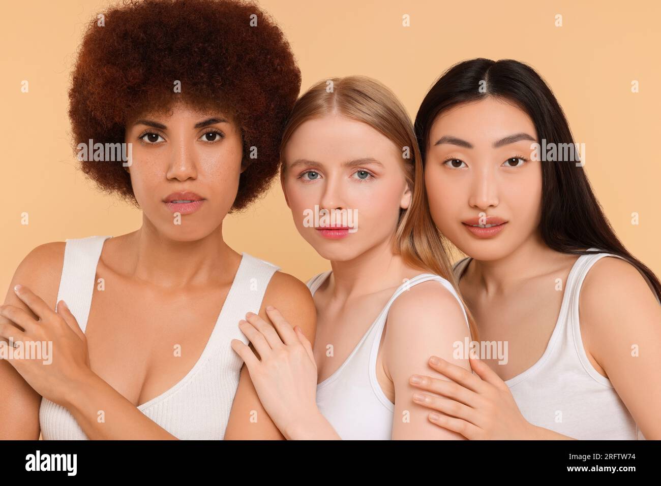 Portrait of beautiful young women on beige background Stock Photo - Alamy