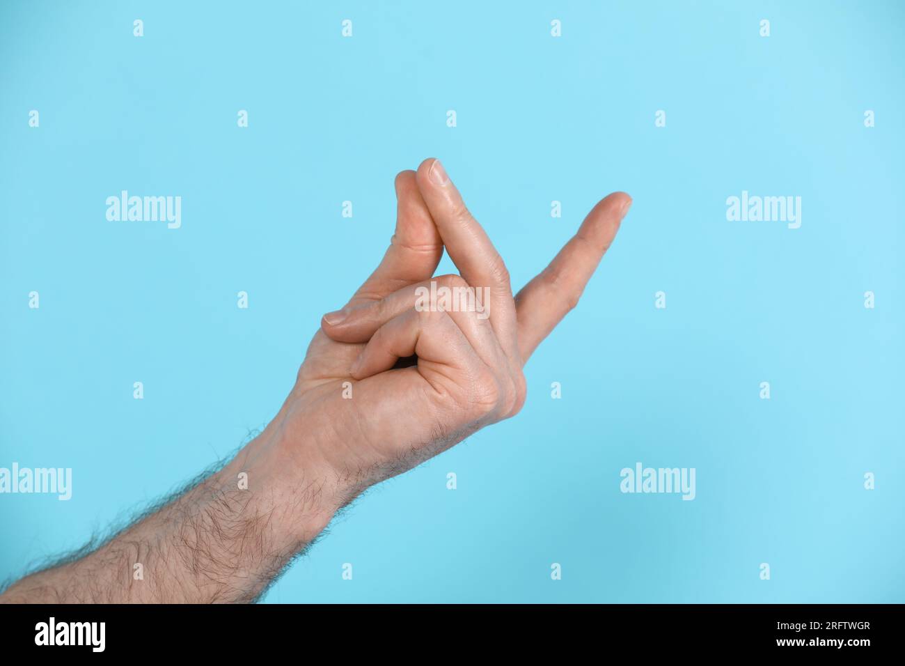 Man snapping his fingers on light blue background, closeup. Bad habit Stock Photo Alamy