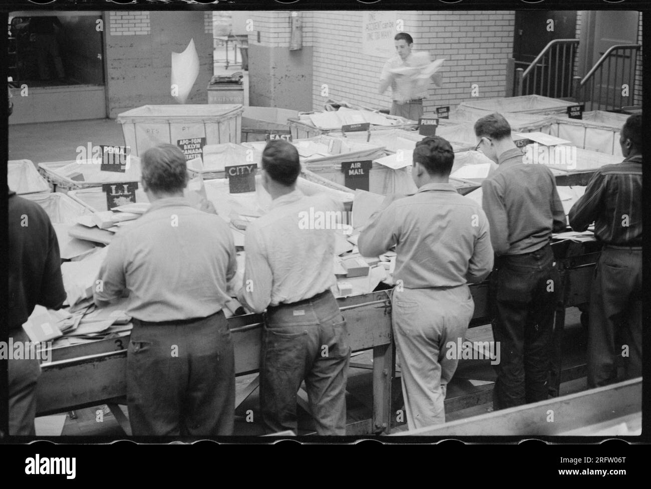 Workers sorting mail at the United States Post Office in New York City, NY in 1957. Stock Photo