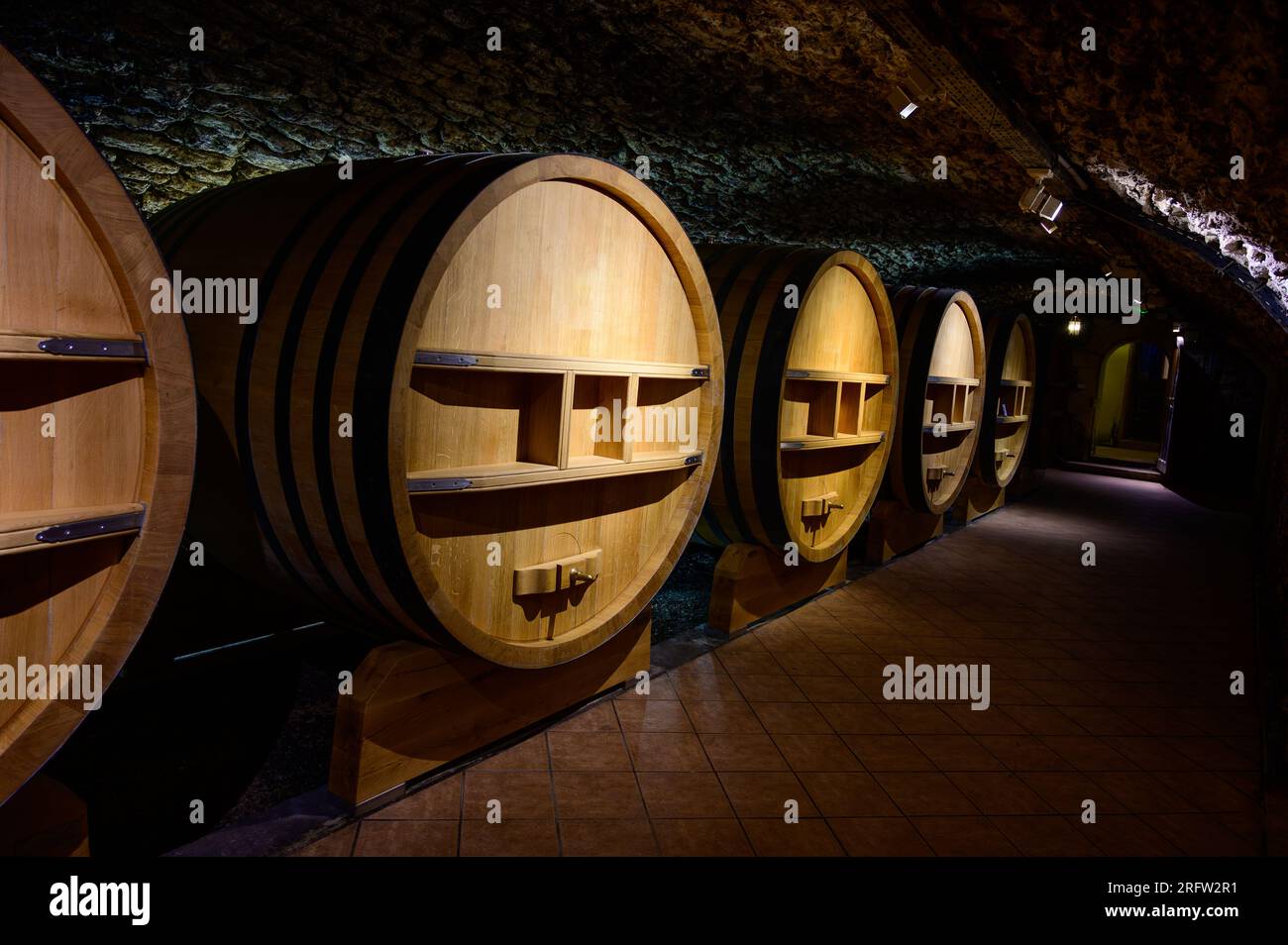 Underground wine cellars with barrels for aging of red dry wine in ChateauneufduPape wine