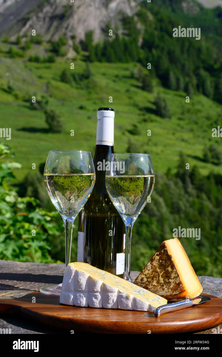 Cheese and wine, glasses of dry white Roussette de Savoie and Vin de Savoie wine from Savoy