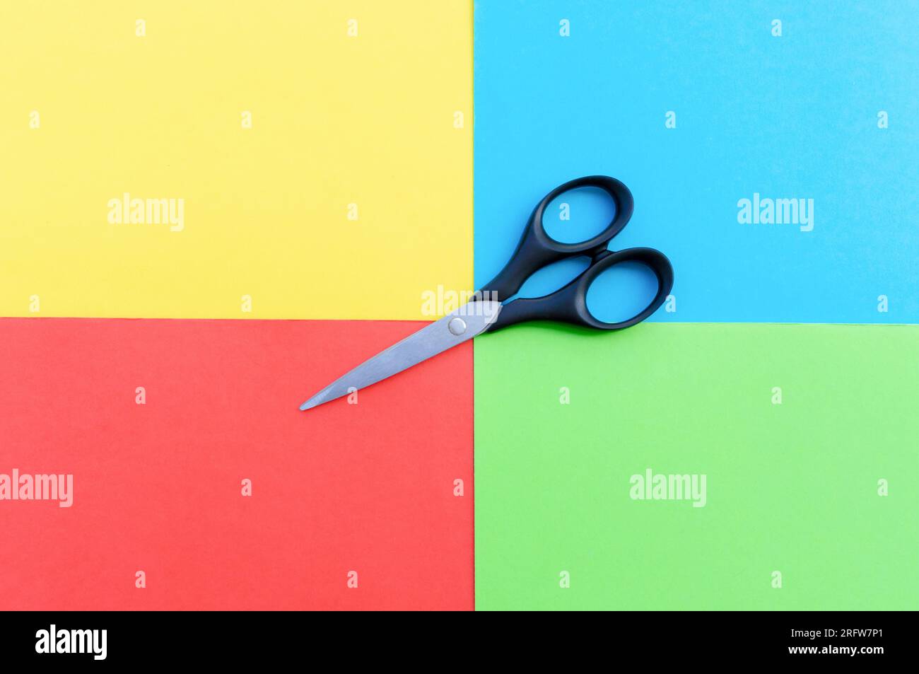Scissors placed on colored papers, after some edits. Stock Photo