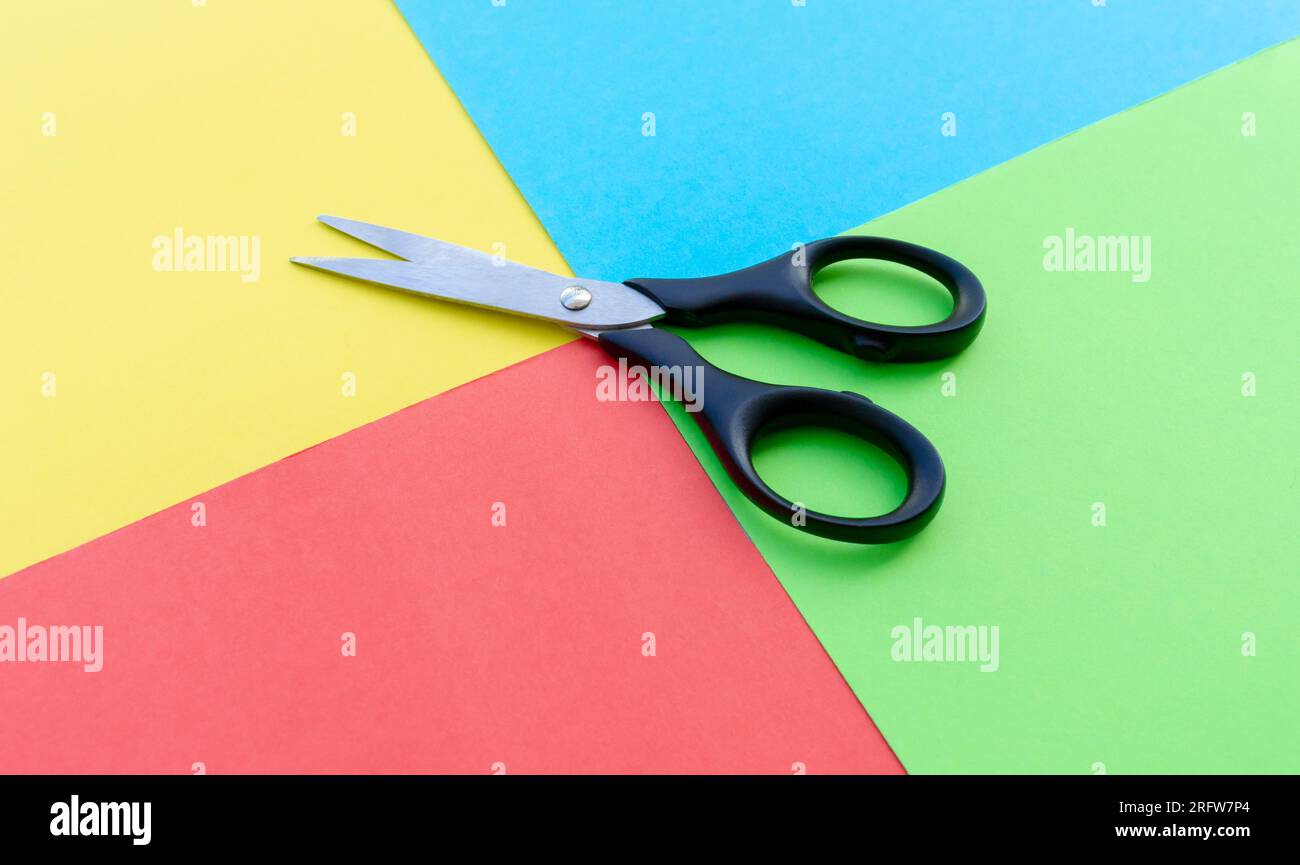 Scissors placed on colored papers, after some edits. Stock Photo