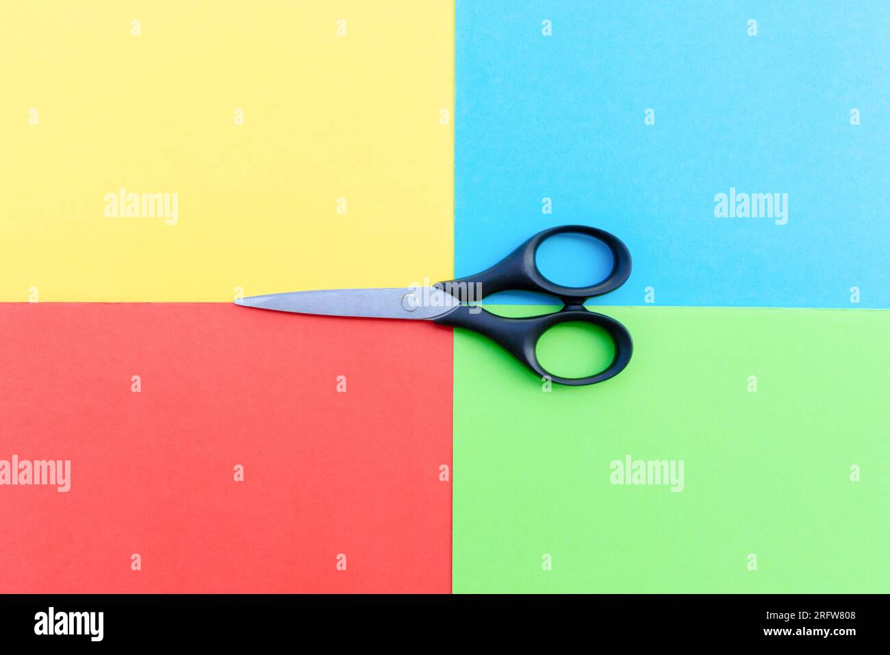 Scissors placed on colored papers, after some edits. Stock Photo