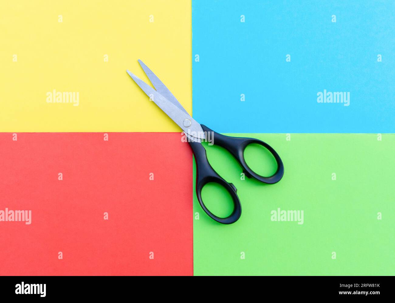 Scissors placed on colored papers, after some edits. Stock Photo