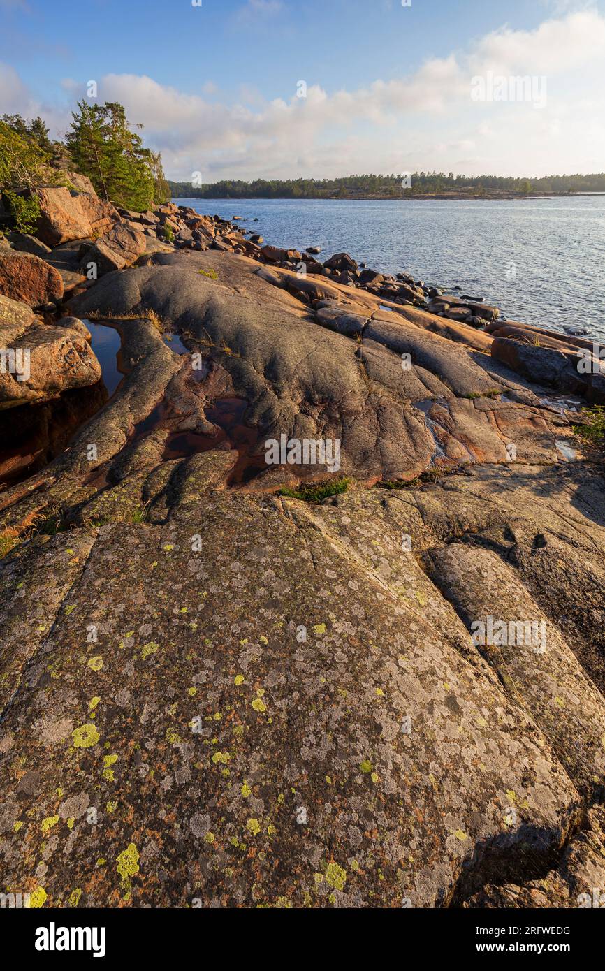 Scenic landscape of a rocky cliff by the sea at Geta in Åland Islands, Finland, on a sunny day in the summer. Off the beaten path in the nature. Stock Photo