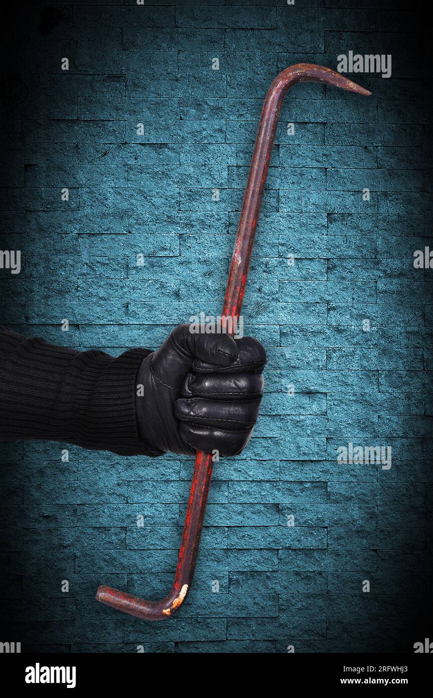 hand holding nail puller on blue background Stock Photo