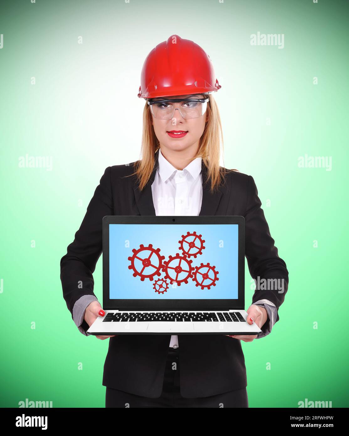 woman engineer holding pc with cogs and geers Stock Photo