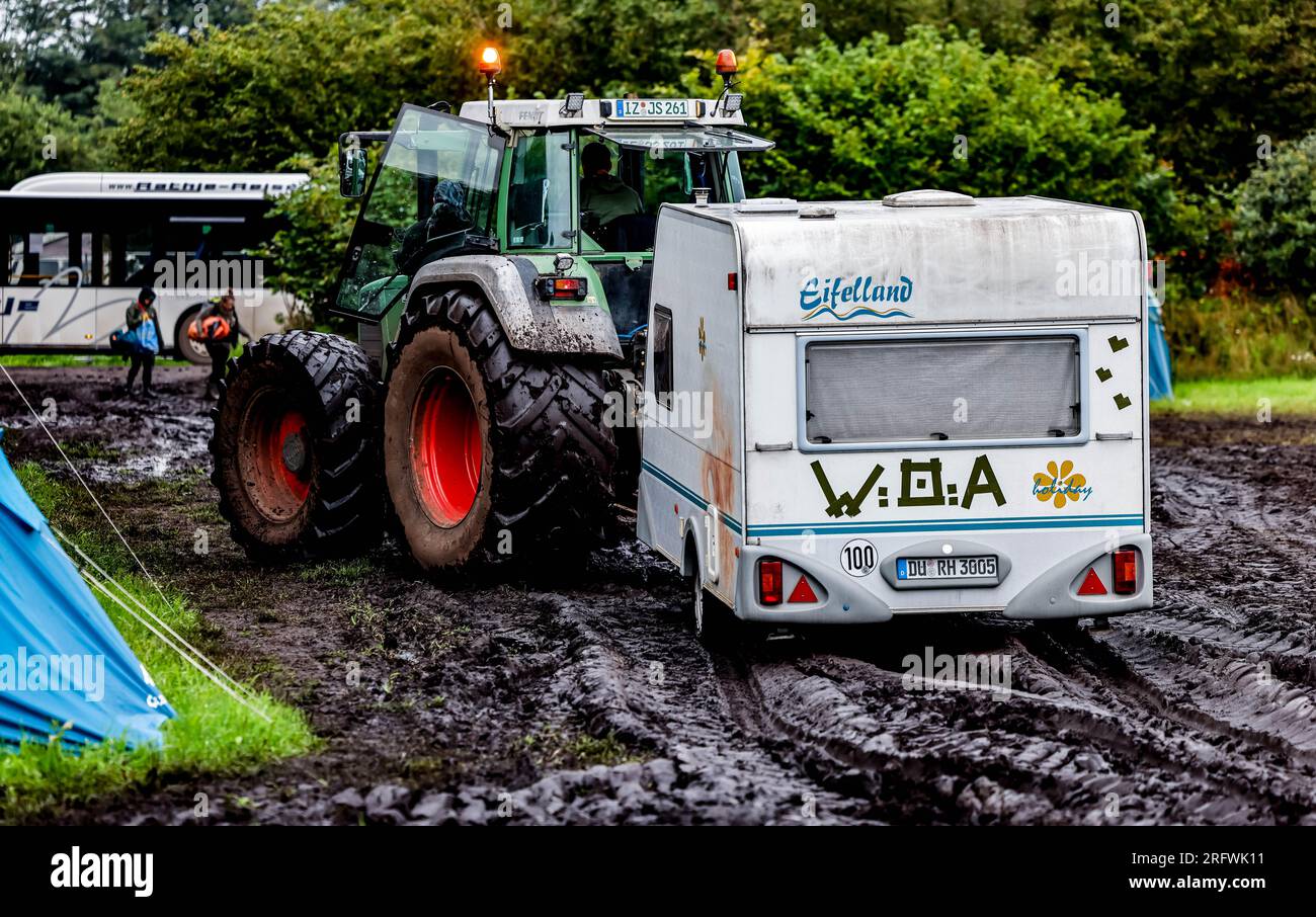 Wacken, Germany. 06th Aug, 2023. A tractor pulls a caravan from the muddy  camping area of the Wacken Open Air. After four days of heavy metal party,  tens of thousands of metal