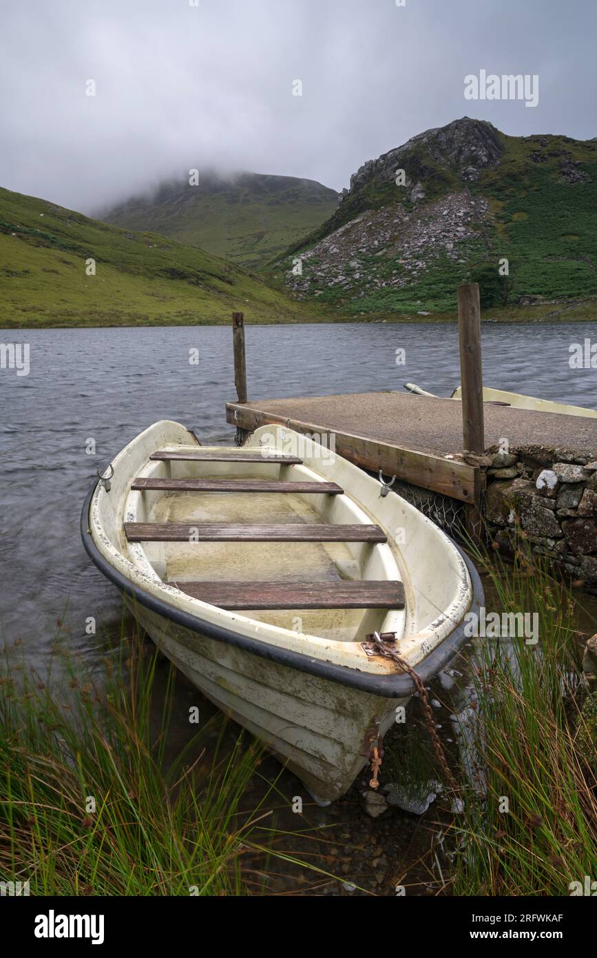 Fishing boat, moored next to jetty, Llyn y Dywarchen, Lake, Gwynedd Stock Photo