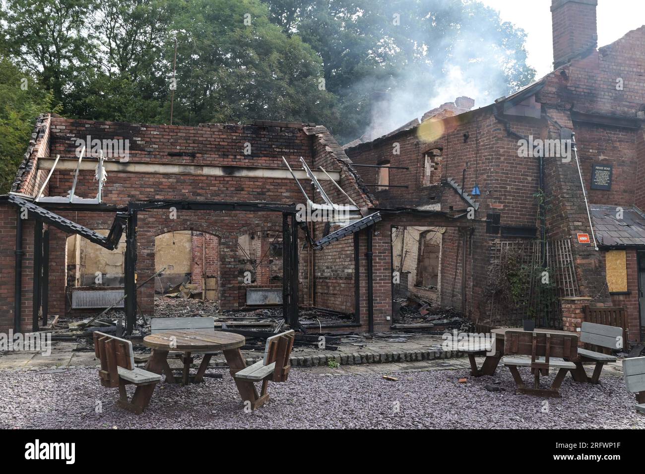 Himley Road, Himley, 6th August 2023: The burnt out remains of The Crooked House pub which was set alight around 10pm on Saturday night. - West Midlands and Staffordshire Fire and Rescue Service were called at 10pm on Saturday night after The Crooked House was set on fire. The former boozer was located in Himley (Staffordshire) near the town of Dudley. The blaze tore through the 18th century wonky pub which had been trading for 192 years until it closed in July. The building boasted a unique leaning effect which caused several optical illusions including marbles that would seemingly roll up wa Stock Photo