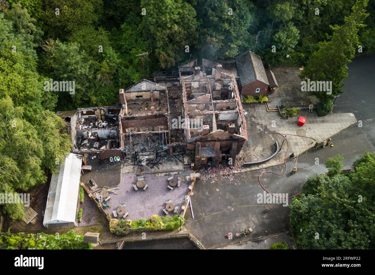 Himley Road, Himley, 6th August 2023: The burnt out remains of The Crooked House pub which was set alight around 10pm on Saturday night. - West Midlands and Staffordshire Fire and Rescue Service were called at 10pm on Saturday night after The Crooked House was set on fire. The former boozer was located in Himley (Staffordshire) near the town of Dudley. The blaze tore through the 18th century wonky pub which had been trading for 192 years until it closed in July. The building boasted a unique leaning effect which caused several optical illusions including marbles that would seemingly roll up wa Stock Photo