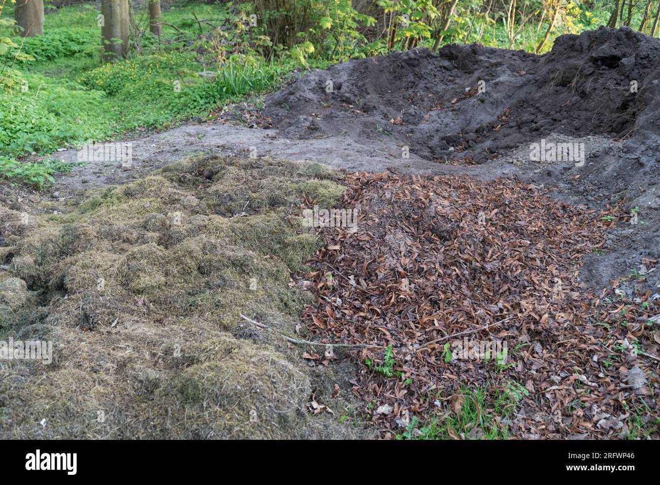 Compost heap with leaves, lawn clippings and mature compost soil Stock Photo