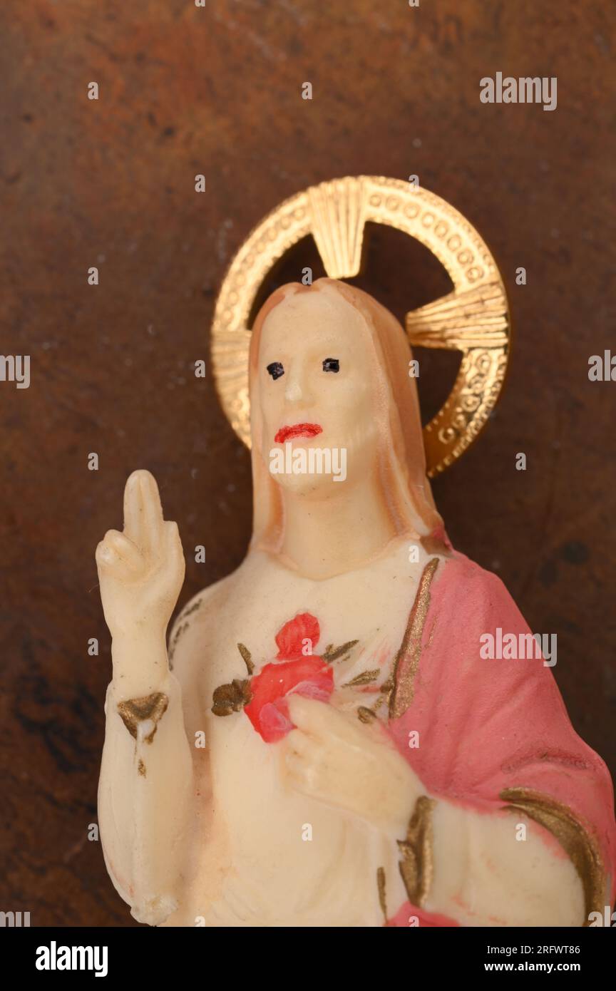 Model of Jesus Christ with halo holding hand in blessing and pointing to Sacred Heart Stock Photo