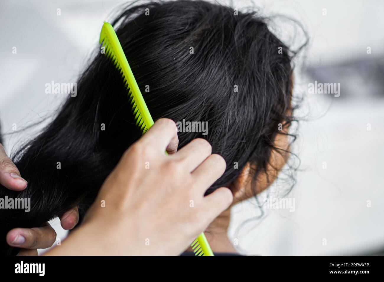 A mother combing her daughter's hair Stock Photo
