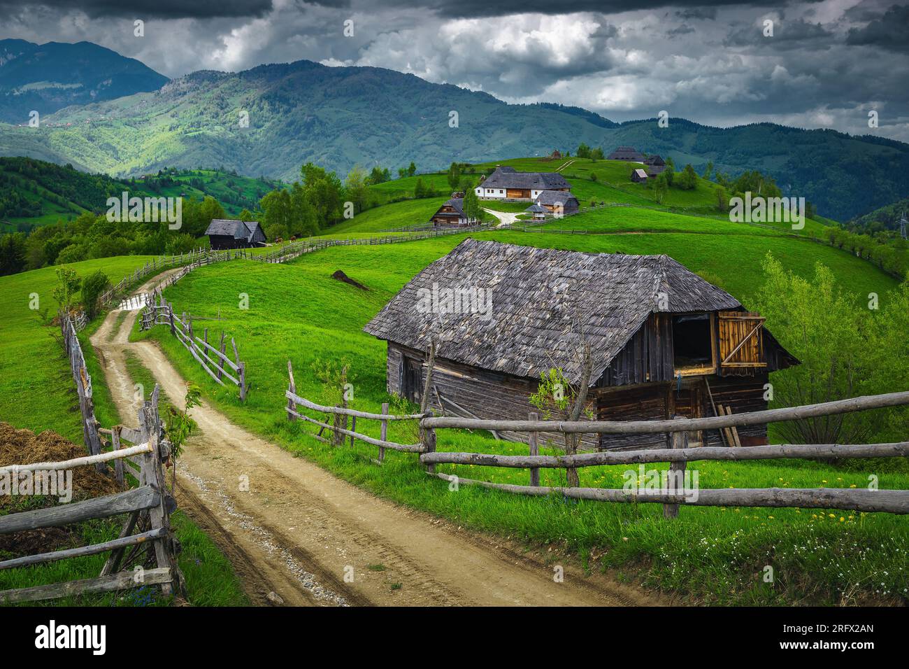 Green pastures and gardens with wooden barns on the hills, Transylvania, Romania, Europe Stock Photo