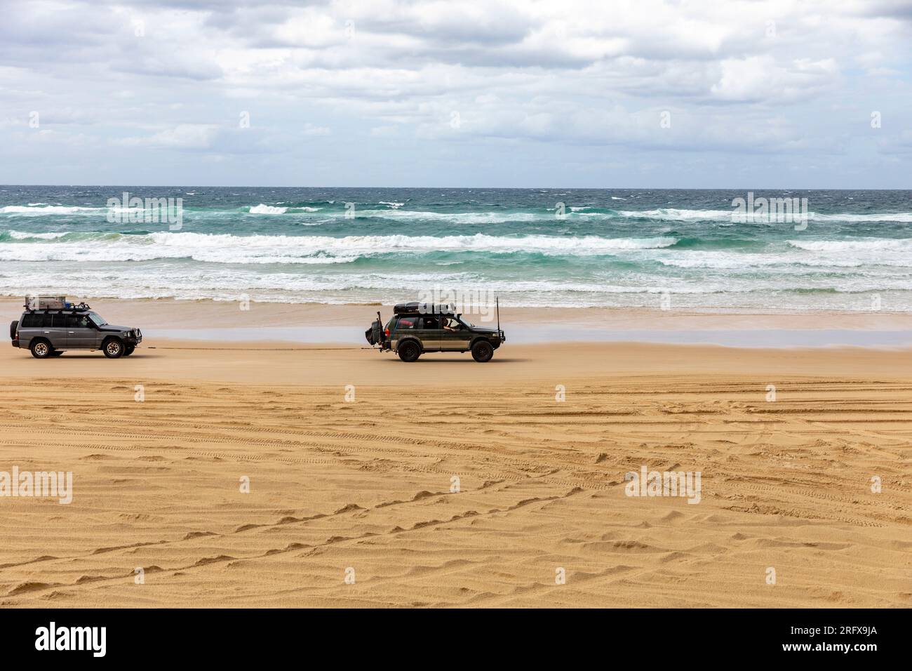 Fraser Island 4WD driving on 75 mile beach, one 4x4 vehicle tows another that has broken down,Queensland,Australia Stock Photo