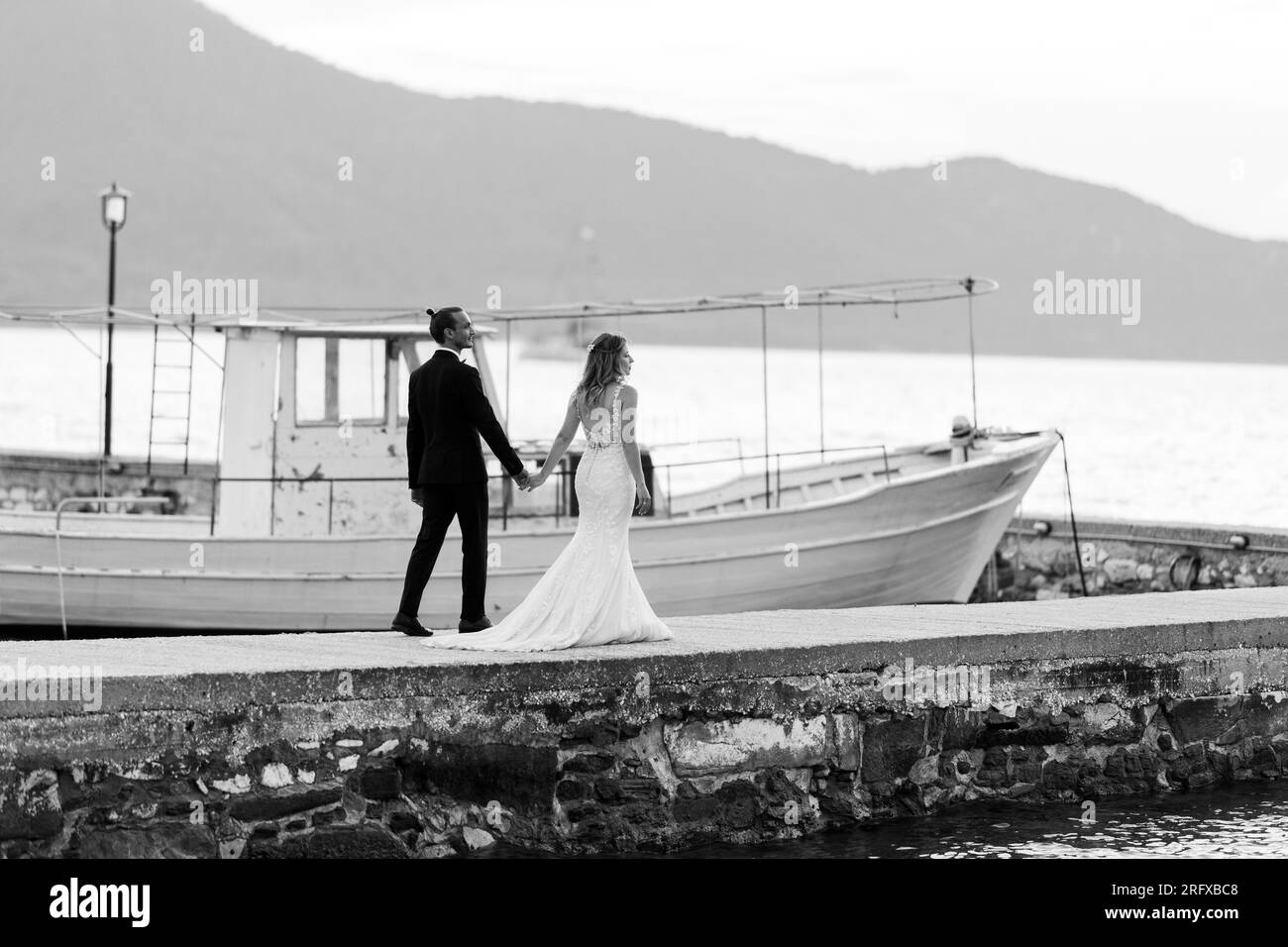 Ein Brautpaar das einen Spaziergang macht und dabei den Sonnenuntergang in Griechenland genießt. Stock Photo