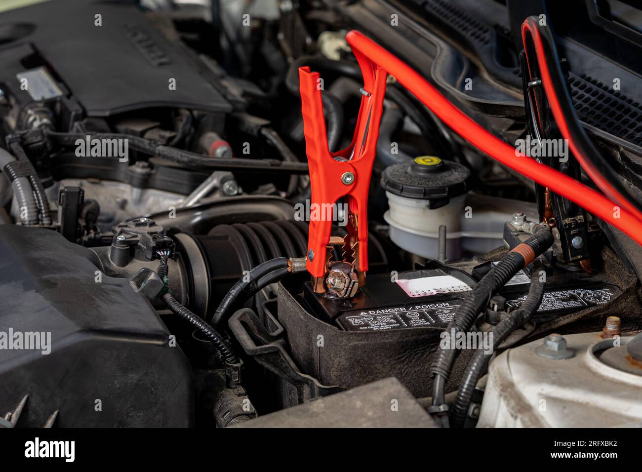 Booster cables attached to dead battery of car. Jump starting, battery