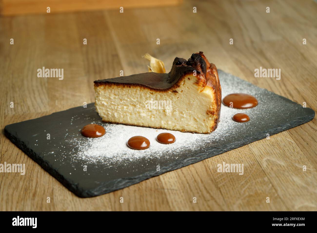 Basque burnt cheesecake with raspberry puree Stock Photo - Alamy