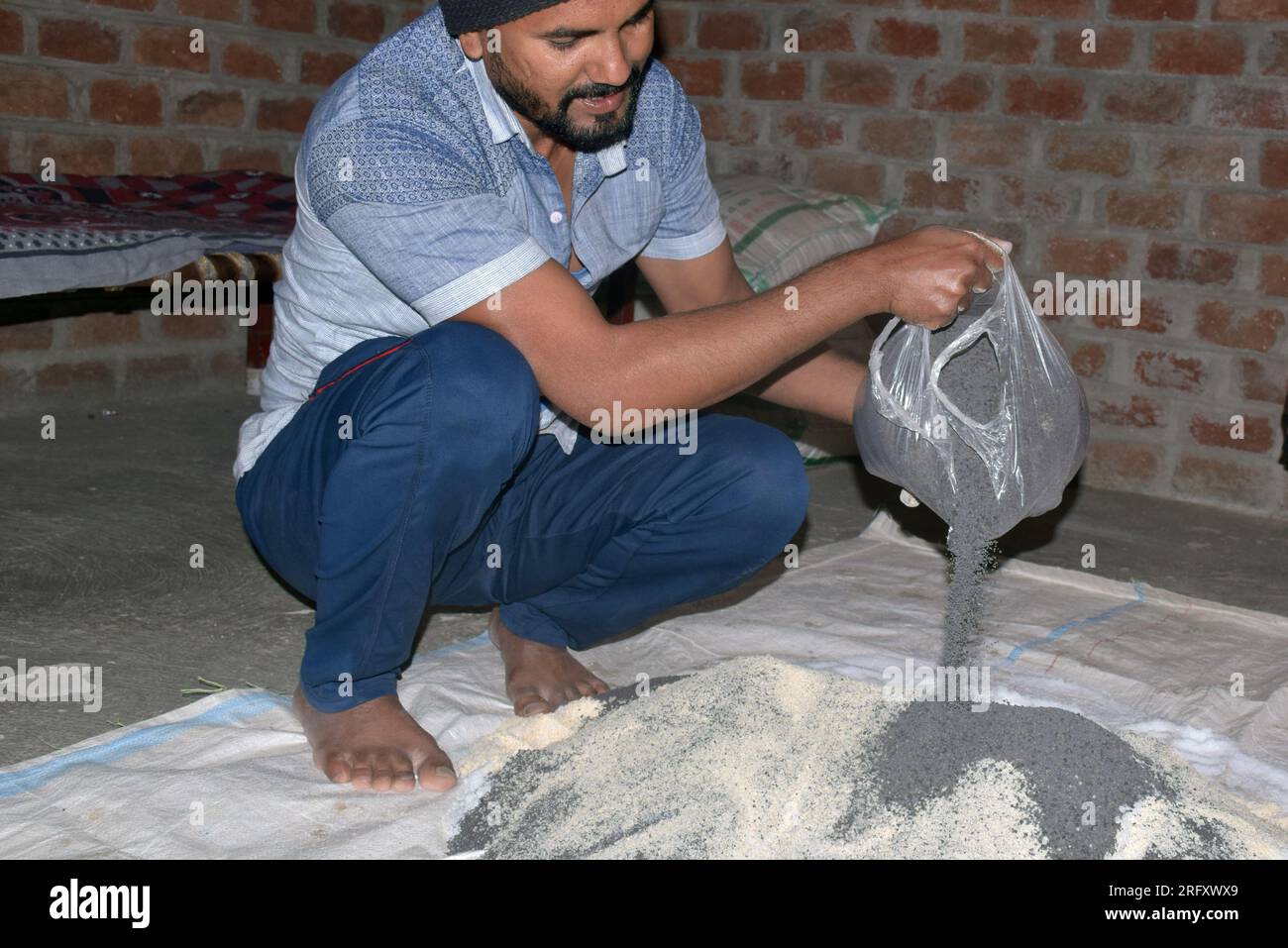 Indian farmer mixing different fertilizer elements in manure, at home